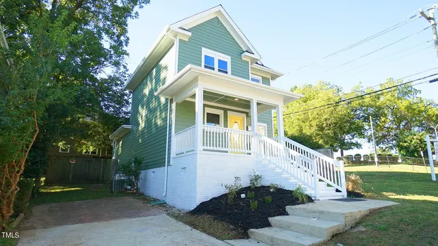 a view of a white house with a yard and plants