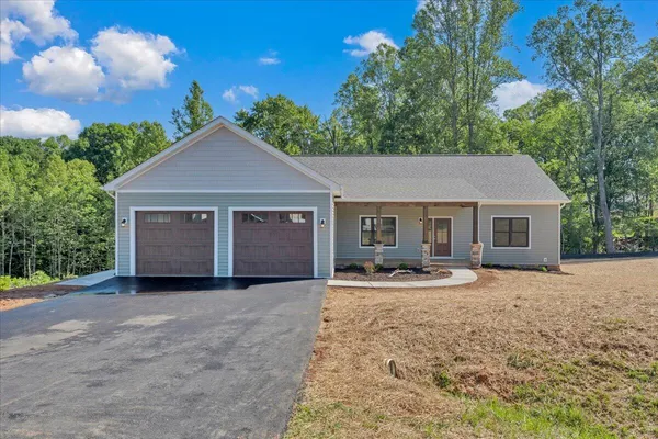 a front view of a house with yard outdoor seating and garage