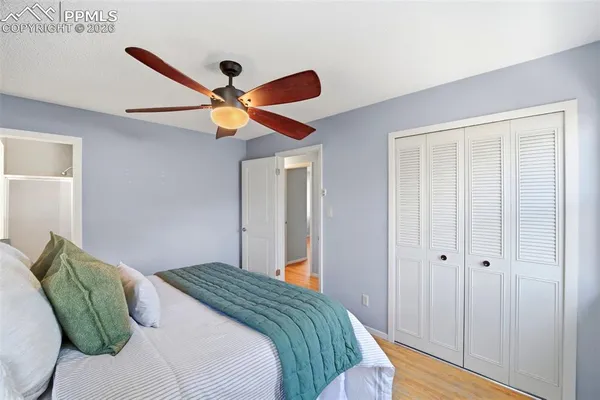 a bedroom with a bed and a ceiling fan