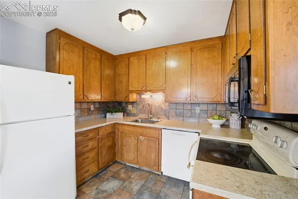a kitchen with a sink a refrigerator and cabinets