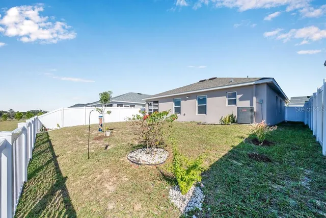 front view of house with a yard and potted plants