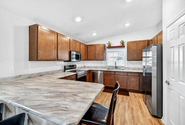 a kitchen with stainless steel appliances granite countertop a sink stove and microwave