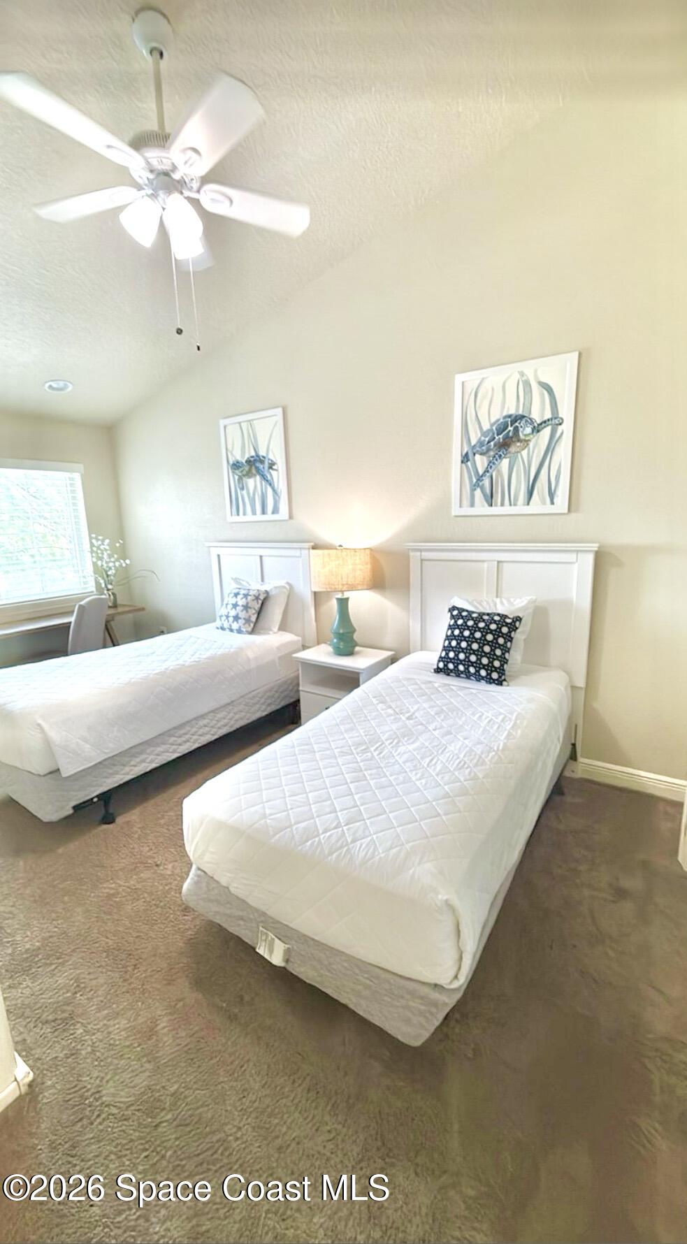 2709 Cutlass Point Lane, Unit 103 Merritt Island, FL 32953 - Photo 19 of 31 a bedroom with beds and a chandelier