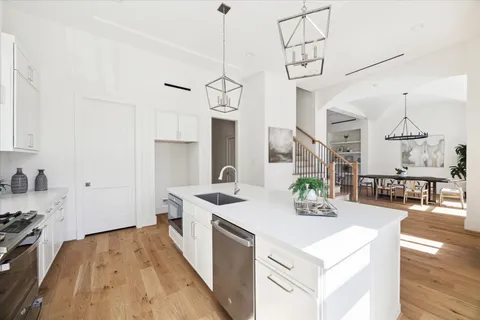 a kitchen with stainless steel appliances a sink and white cabinets