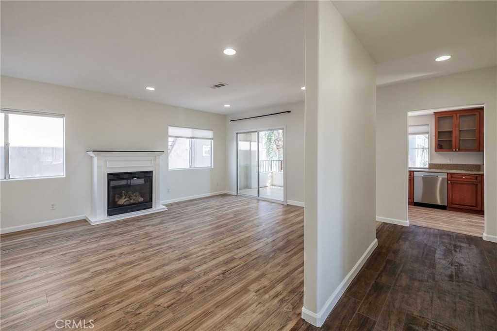 1128 Pacific Avenue Long Beach, CA 90813 - Photo 5 of 33 a view of a kitchen and an empty room with wooden floor fireplace and a window