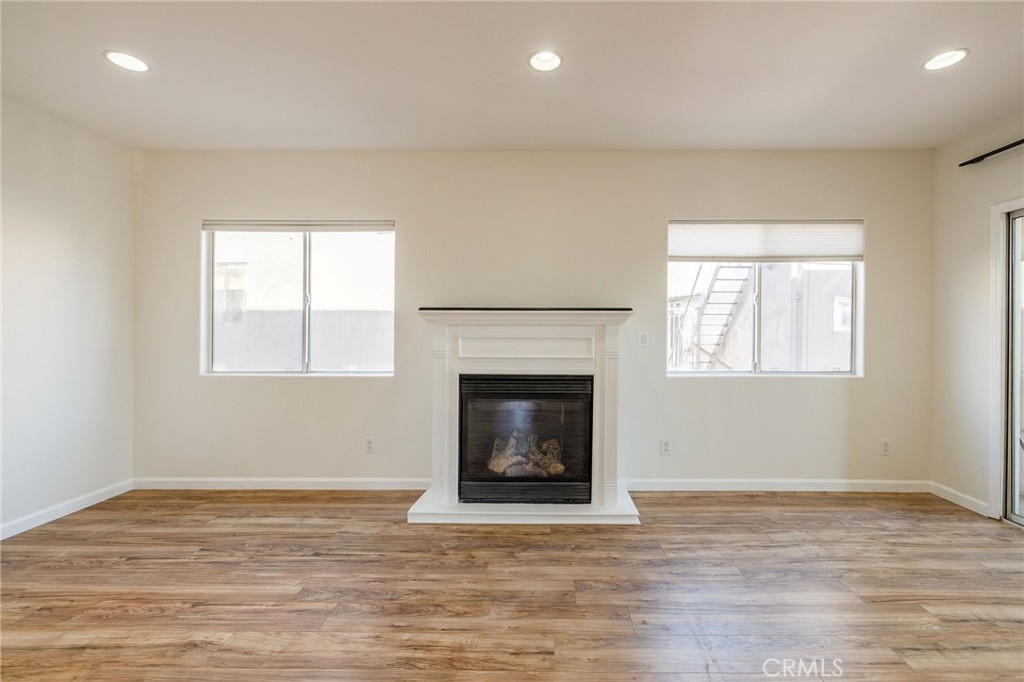 1128 Pacific Avenue Long Beach, CA 90813 - Photo 7 of 33 a view of an empty room with wooden floor fireplace and a window