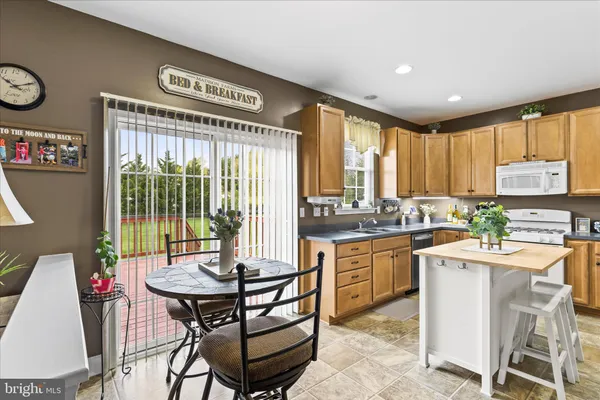 a kitchen with a dining table chairs and large window