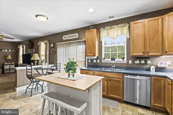 a kitchen with a stove a sink and white cabinets with wooden floor