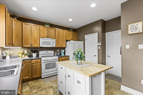 a kitchen with a stove a sink a refrigerator and a microwave