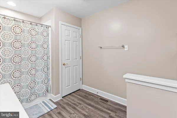 a bedroom with a bed a chandelier and a dresser