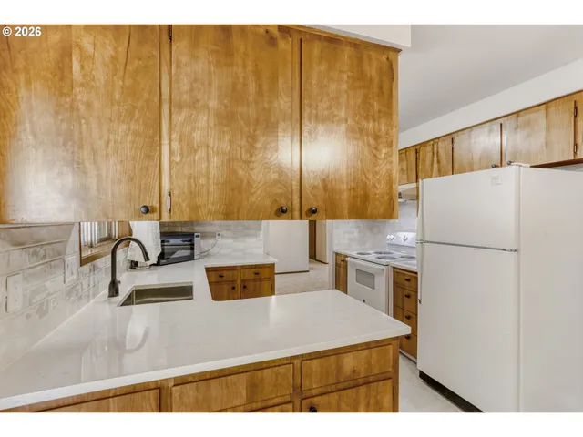 a kitchen with a sink a refrigerator and a stove