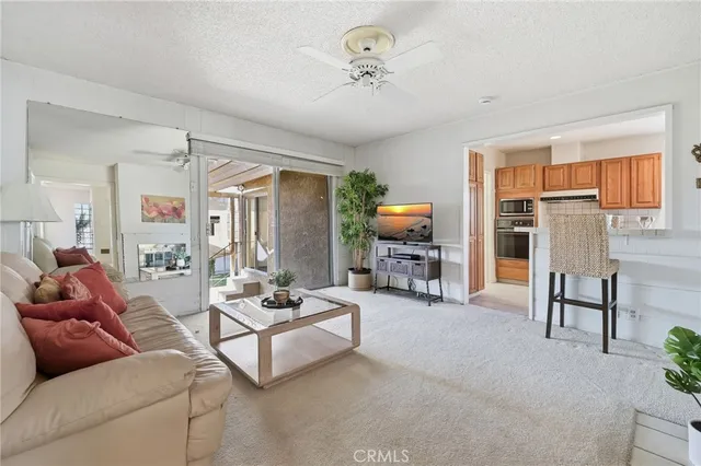 a living room with furniture a flat screen tv and a large window