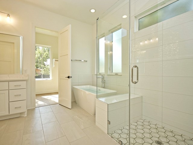 7500 St Cecelia Street Austin, TX 78757 - Photo 11 of 31 a bathroom with a tub a sink a mirror and a shower