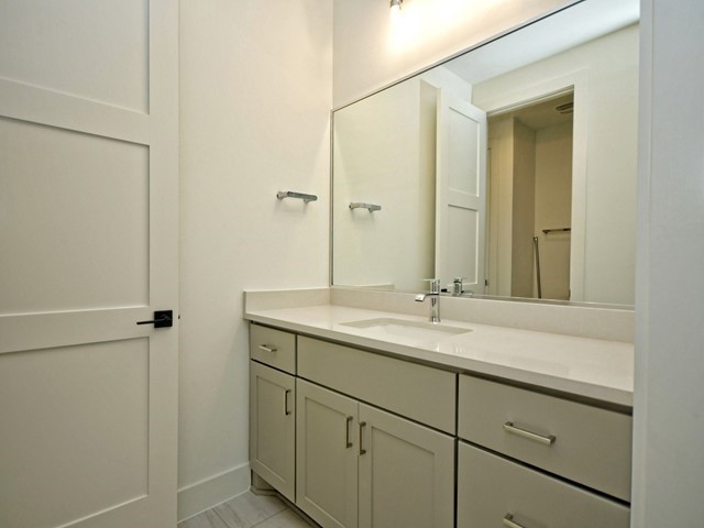 7500 St Cecelia Street Austin, TX 78757 - Photo 24 of 31 a bathroom with a granite countertop sink and mirror