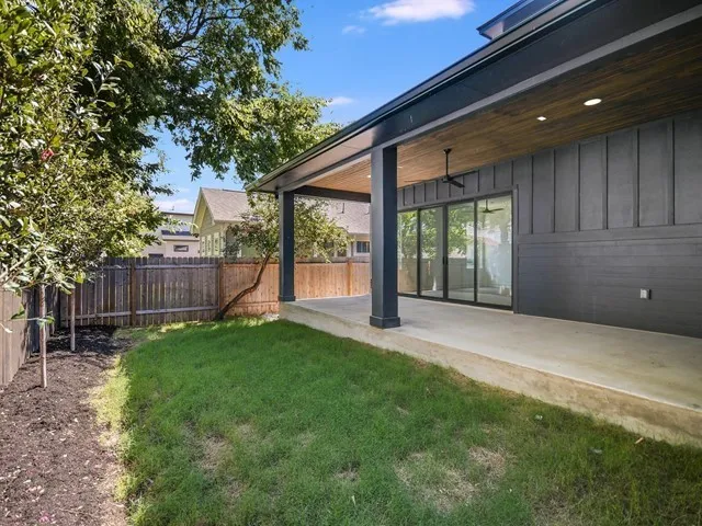 a view of a house with backyard and a tree