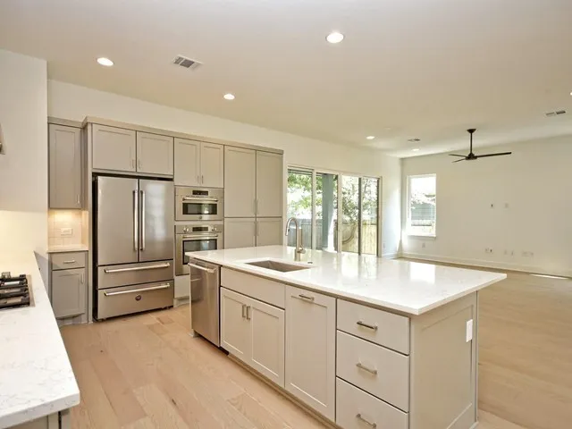 a kitchen with white cabinets and stainless steel appliances