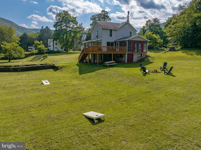 an aerial view of a house with a yard swimming pool and outdoor seating