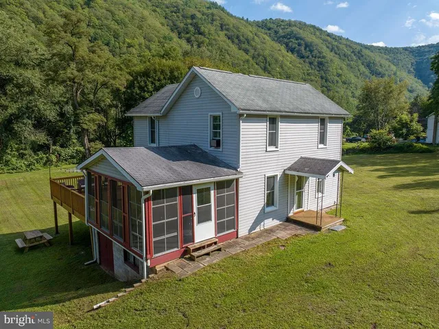 a bedroom with a bed a dresser and wooden floor