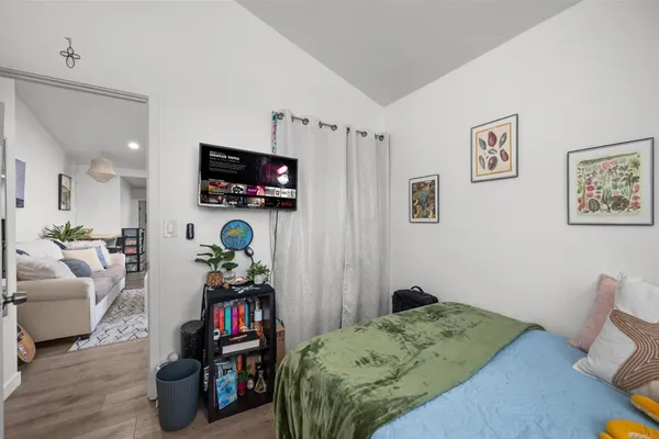 a bedroom with bed and a flat tv screen on dresser