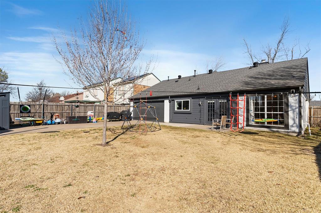 7518 Bayview Drive Rowlett, TX 75088 - Photo 20 of 22 Rear view of property featuring a fenced backyard, a patio area, and a shingled roof