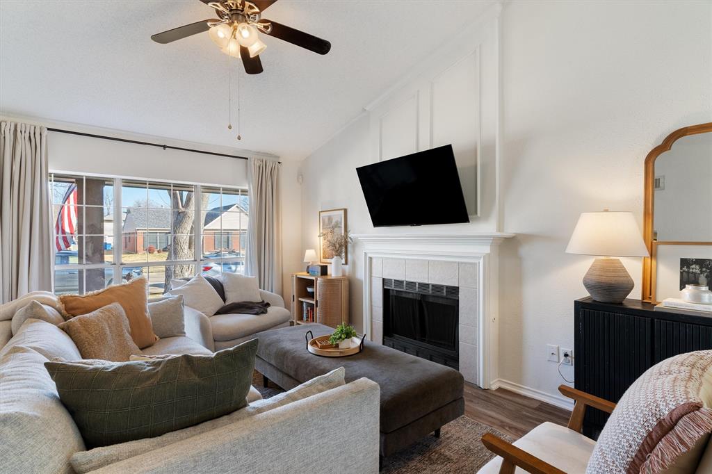 7518 Bayview Drive Rowlett, TX 75088 - Photo 3 of 22 Living area featuring ceiling fan, dark wood-style flooring, lofted ceiling, and a tile fireplace