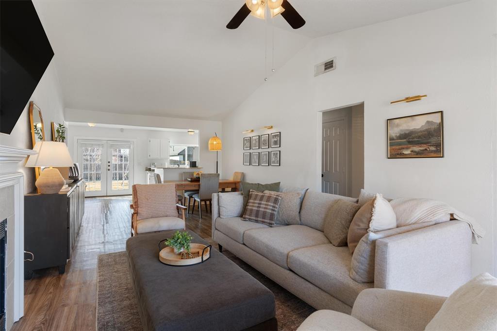 7518 Bayview Drive Rowlett, TX 75088 - Photo 5 of 22 Living room featuring lofted ceiling, wood finished floors, a fireplace, ceiling fan, and french doors