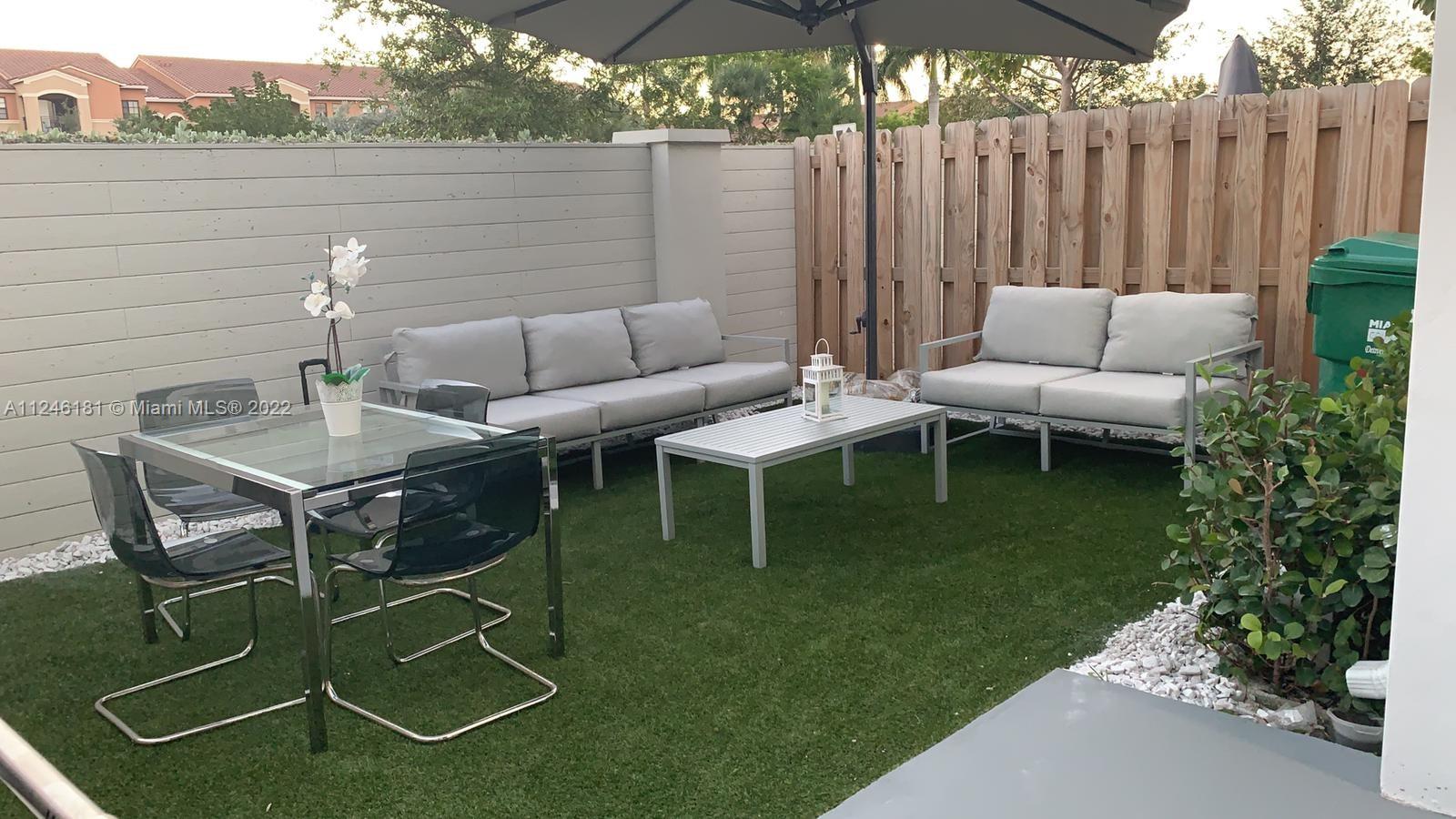 7220 Northwest 103rd Path Doral, FL 33178 - Photo 18 of 19 a backyard of a house with table and chairs