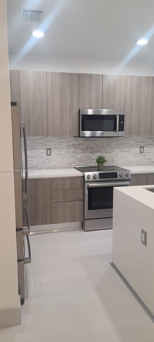 7220 Northwest 103rd Path Doral, FL 33178 - Photo 4 of 19 a kitchen with stainless steel appliances granite countertop a stove a sink and a refrigerator