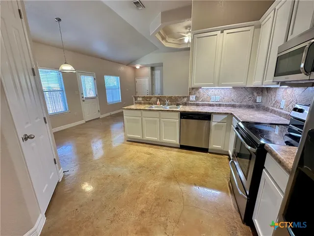 a kitchen with granite countertop a sink stainless steel appliances and cabinets