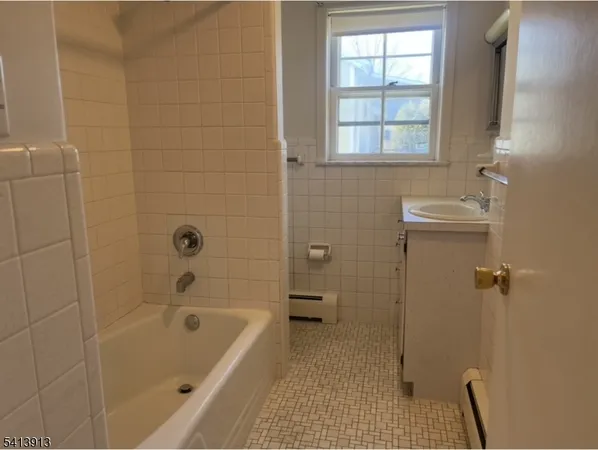 a bathroom with a tub a window and a shower