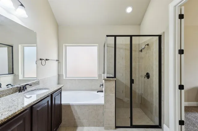 a bathroom with a granite countertop sink a mirror and shower