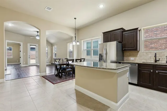 a view of a room with wooden floor chandelier and windows