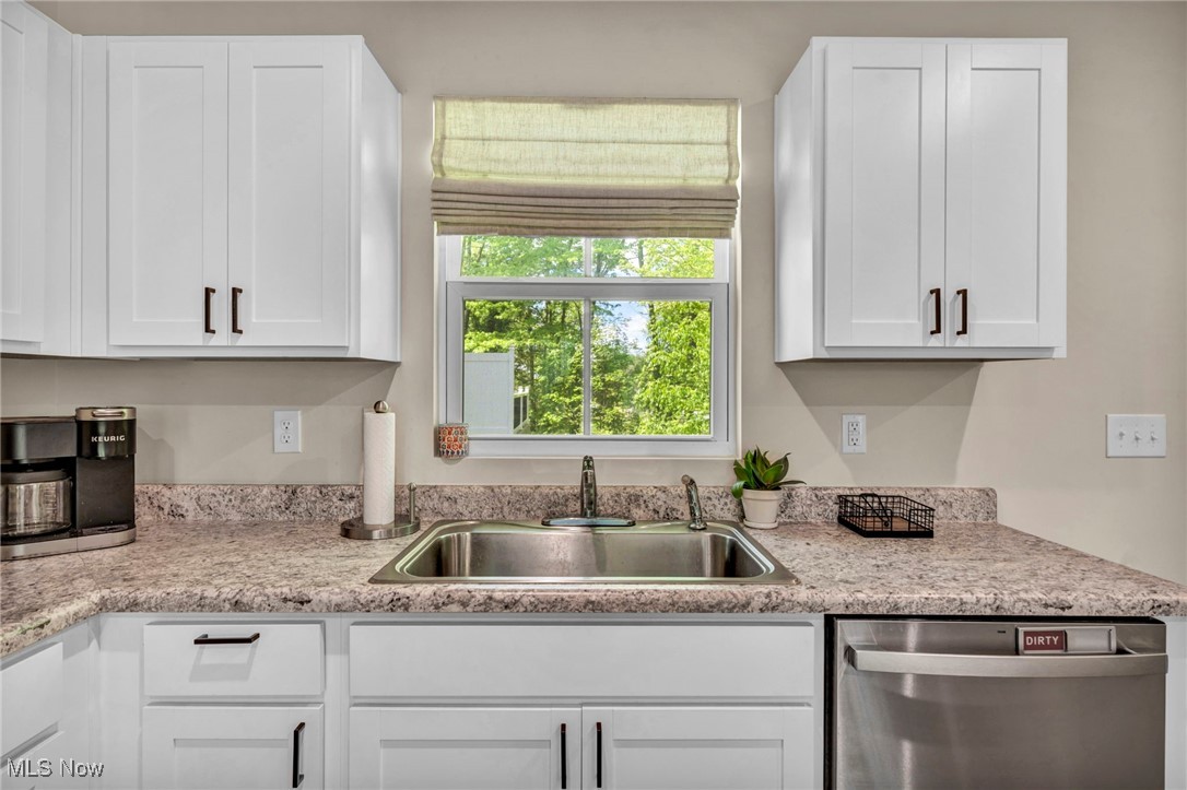 191 Raintree Lane Painesville, OH 44077 - Photo 13 of 35 Kitchen with stainless steel dishwasher, white cabinets, and light stone counters