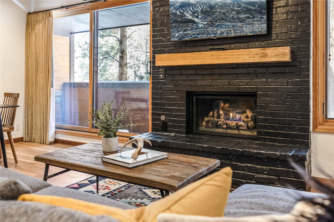 800 Columbine Road, Unit 5 Breckenridge, CO 80424 - Photo 12 of 38 a living room with a fireplace a table and a large window