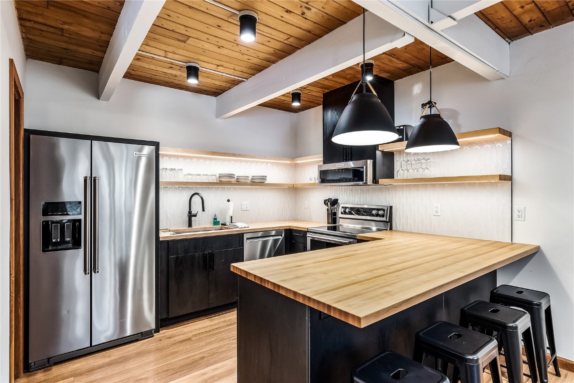800 Columbine Road, Unit 5 Breckenridge, CO 80424 - Photo 2 of 38 a kitchen with stainless steel appliances a table chairs and wooden floors