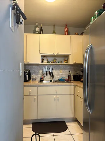 a kitchen with a sink a refrigerator and cabinets