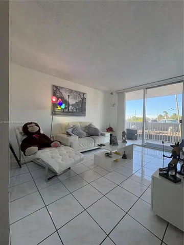 a living room with furniture and a floor to ceiling window