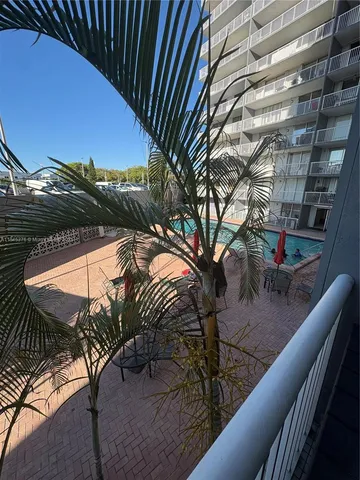 a front view of a building with balcony and trees