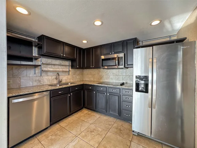 a kitchen with stainless steel appliances granite countertop a refrigerator sink and cabinets