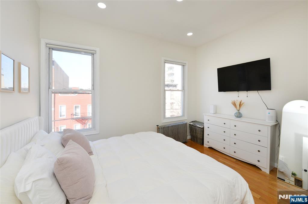 209 Adams Street, Unit 5 Hoboken, NJ 07030 - Photo 11 of 15 a bedroom with a bed and a flat screen tv