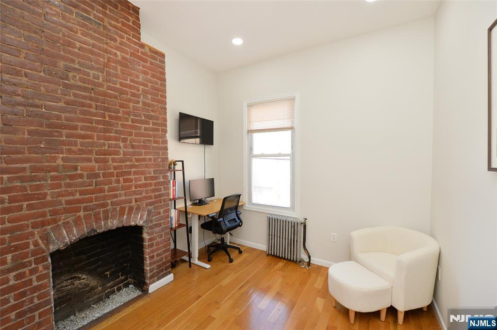 209 Adams Street, Unit 5 Hoboken, NJ 07030 - Photo 13 of 15 a living room with furniture and a fireplace