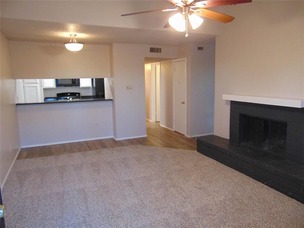 9611 Walnut Street, Unit 1303 Dallas, TX 75081 - Photo 1 of 16 a view of empty room with a fireplace and fan