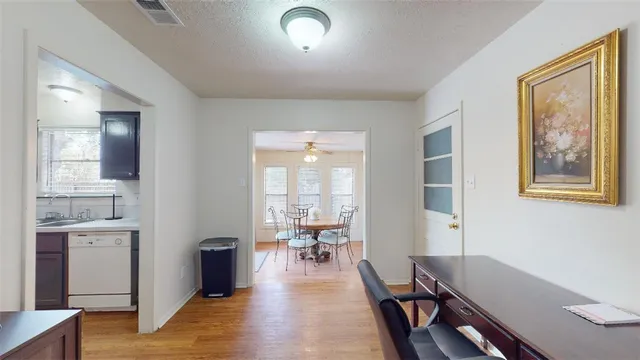 a view of a hallway with furniture and wooden floor