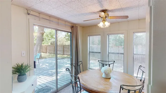 a dining room with furniture a large window and wooden floor