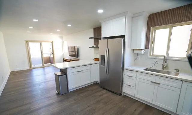 a kitchen with a refrigerator cabinets and wooden floor