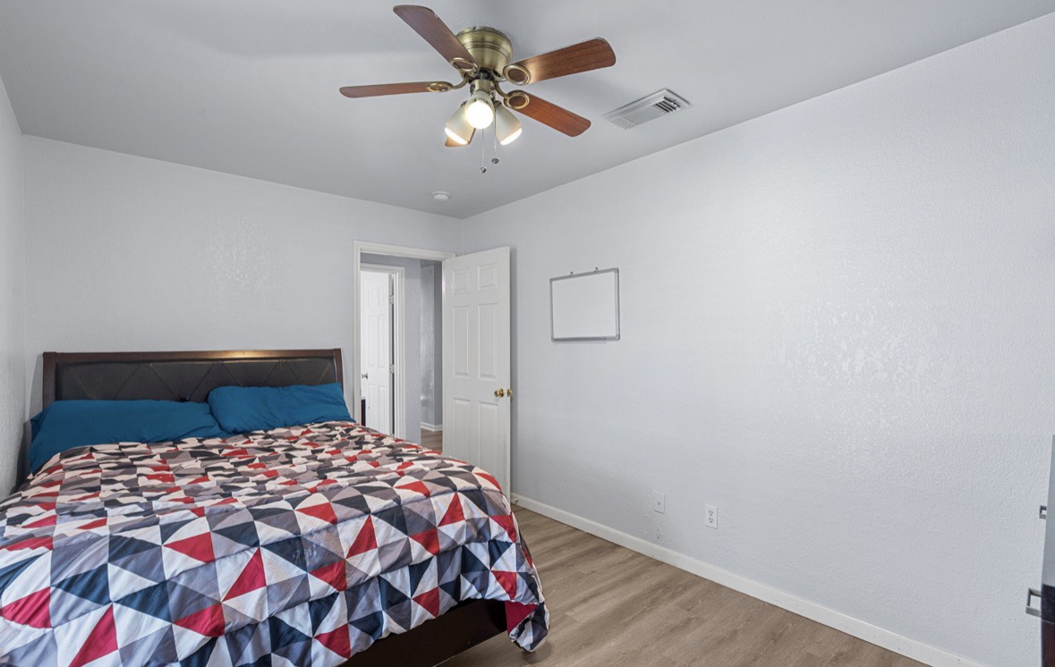 620 6th Street Dickinson, TX 77539 - Photo 25 of 36 a bedroom with a large bed and a chandelier