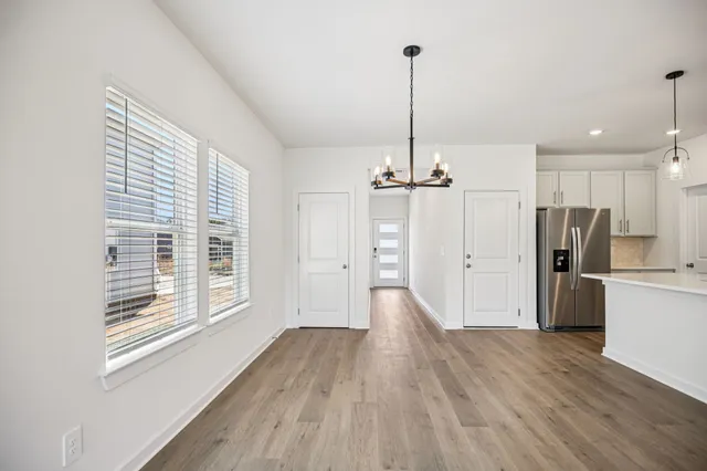 a view of empty room with wooden floor and window