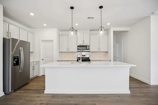 a kitchen with stainless steel appliances a refrigerator and cabinets
