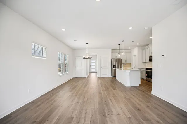 an empty room with wooden floor and window