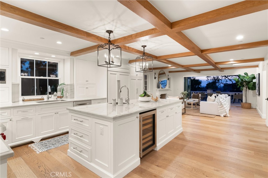 503 Hazel Drive Corona del Mar, CA 92625 - Photo 9 of 39 a large white kitchen with a stove a sink a window and a dining table
